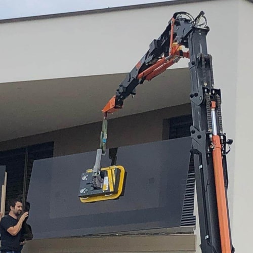 Balkonbrüstung aus Glas wird mit Glassauger in Position gebracht Balkonbrüstung aus Glas wird mit Glassauger in Position gebracht